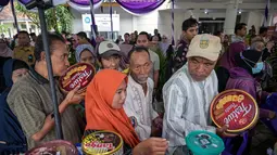 Aksi ini rutin dilaksanakan dalam momen khusus seperti bulan Ramadan. Tampak dalam foto, masyarakat menerima barang-barang gratis seperti pakaian, bahan makanan pokok, dan perlengkapan rumah tangga yang disediakan oleh Asosiasi Organisasi Wanita (GOW) dan pemerintah daerah selama kegiatan aksi sosial tahunan di bulan Ramadan, Surabaya pada Senin 2 Maret 2026. (JUNI KRISWANTO/AFP)