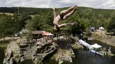 Seorang peserta melompat ke dalam air saat kompetisi cliff diving di kawasan Bohemian, Republik Ceko, Jumat (31/7/2015). (REUTERS/David W Cerny)