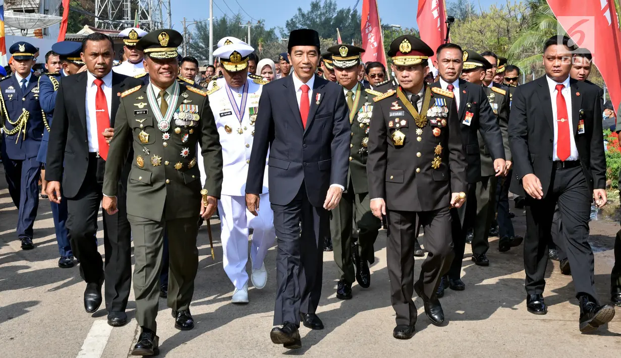 Presiden Joko Widodo (tengah) didampingi Kapolri, Tito Karnavian (kanan) dan Panglima TNI Jenderal Gatot Nurmantyo (kiri) berjalan menuju lokasi upacara HUT ke-72 TNI di Pelabuhan Indah Kiat, Banten (5/10). (Liputan6.com/Pool/Agus Suparto)
