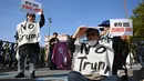 Para demonstran Korea Selatan yang mengenakan spanduk bertuliskan "Tolak Trump" memegang plakat selama demonstrasi yang mengecam tekanan Presiden AS Donald Trump untuk meningkatkan investasi Korea Selatan di AS, di Gyeongju pada 29 Oktober 2025, menjelang KTT Kerja Sama Ekonomi Asia-Pasifik (APEC). (Jung Yeon-je/AFP)