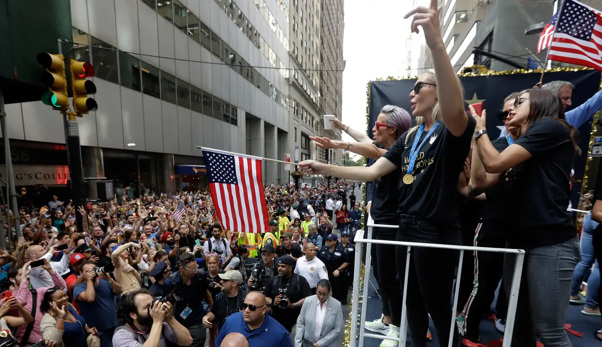 Para pemain timnas sepak bola wanita Amerika Serikat (AS) menaiki kendaraan hias saat parade kemenangan Piala Dunia Wanita 2019 di New York, AS, Rabu (10/7/2019). AS menjuarai Piala Dunia Wanita 2019 usai mengalahkan Belanda di final. (AP Photo/Richard Drew)