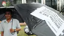 Aktivis dari Gema Tapteng mengenakan payung hitam saat melakukan aksi unjuk rasa di depan gedung KPK, Jakarta, Kamis (26/4). Suap tersebut terkait sengketa Pilkada Tapanuli Tengah 2011 lalu. (Merdeka.com/Dwi Narwoko)