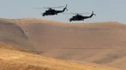 Helikopter militer melintas selama komando strategis dan staf melakukan latihan Center-2019 di lapangan tembak Lyaur, Tajikistan, Rabu (18/9/2019). Prajurit Rusia, Kazakhstan, Kirgistan, Tajikistan, Uzbekistan, India, Pakistan, dan China ikut serta dalam latihan ini. (AP Photo/Grits Sergei)