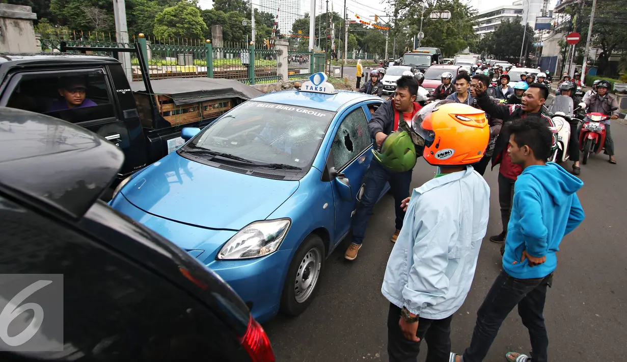 Pengendara ojek online merusak dan melakukan sweeping di kawasan Senayan, Jakarta, Selasa (22/3). Pascabentrok ojek online melakukan sweeping dan perusakan terhadap taksi serta bajaj yang melintas di kawasan tersebut. (Liputan6.com/Immanuel Antonius)