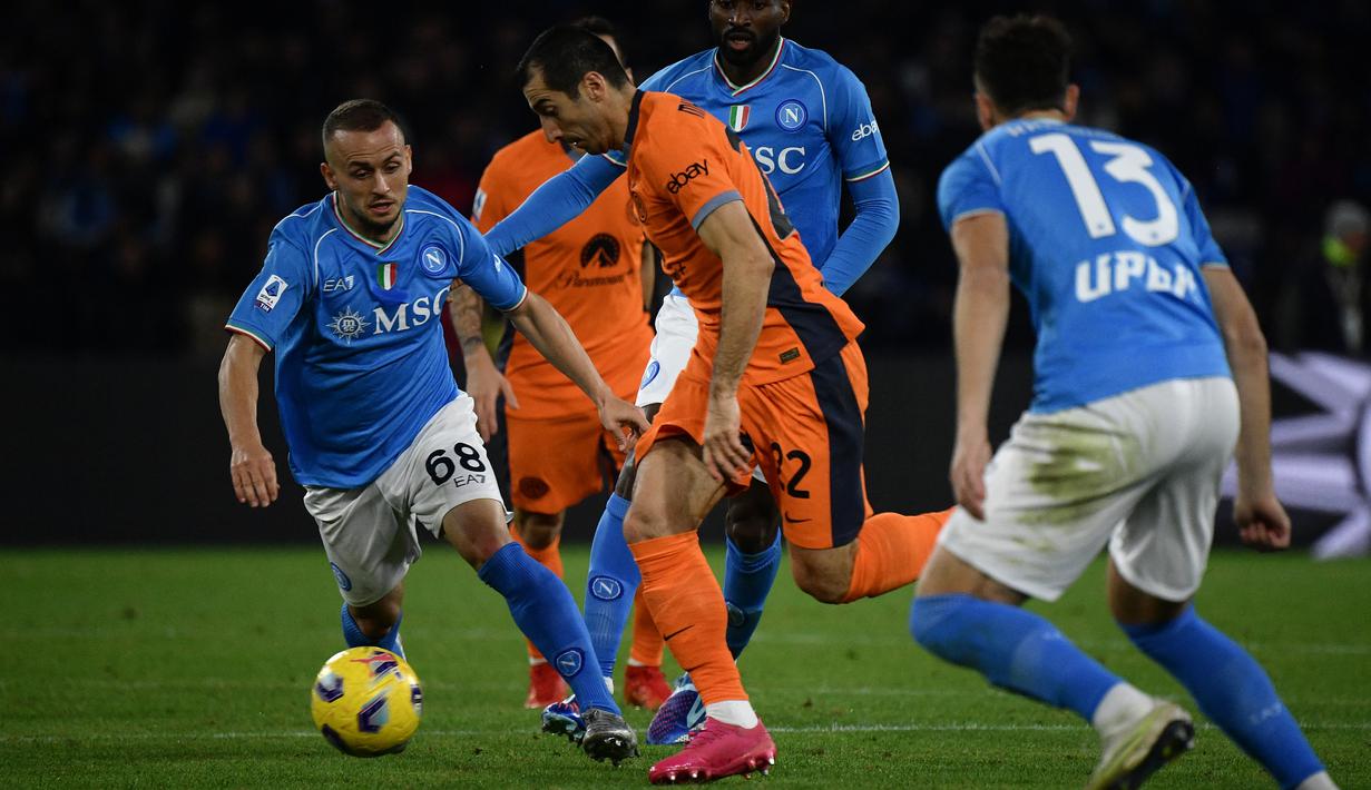 Gelandang Inter Milan #22 Henrikh Mkhitaryan (tengah) berebut bola dengan gelandang Napoli #68 Stanislav Lobotka pada laga pekan ke-14 Serie A 2023/2024 di Stadio Diego Armando Maradona, Senin (04/12/2023) dini hari WIB. (Filippo MONTEFORTE / AFP)