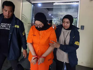 Ayu Puspita, pemilik Wedding Organizer by Ayu Puspita (tengah), digelandang petugas dari unit Kriminal Umum Polda Metro Jaya usai rilis di Gedung Ditreskrimum Polda Metro Jaya, Sabtu (13/12/2025). Polda Metro Jaya merilis kasus penipuan yang dilakukan Ayu Puspita, pemilik Wedding Organizer by Ayu Puspita. (Kapanlagi.com/Budy Santoso)