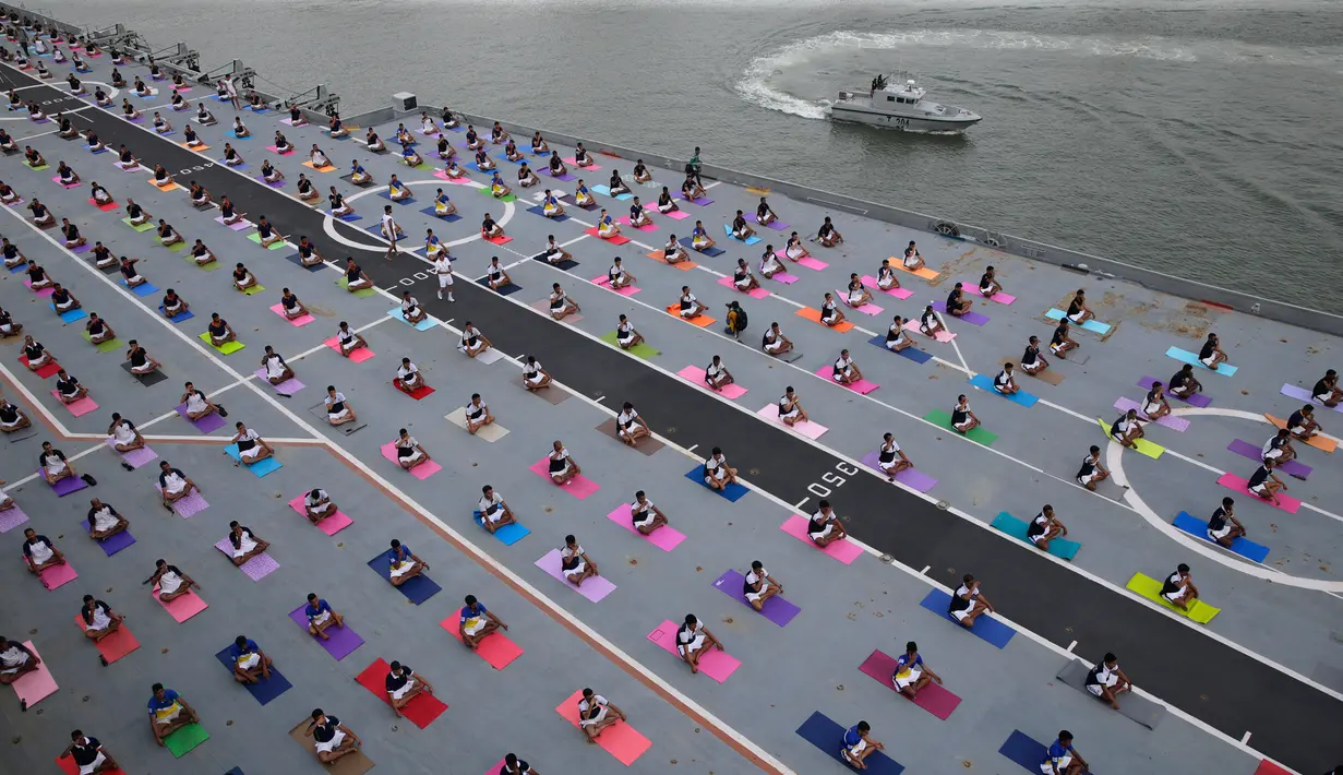 Personel pertahanan India melakukan yoga di dek kapal induk Angkatan Laut India Viraat untuk memperingati Hari Yoga Internasional yang jatuh pada 21 Juni di Mumbai, India, Kamis (21/6). (AP Photo/Rafiq Maqbool)