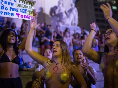 Dua orang wanita bertelanjang dada saat menggelar protes pelarangan aborsi di Rio de Janeiro, Brasil (13/11). Ribuan orang turun ke jalan untuk menggelar protes adanya larangan aborsi di Brasil. (AFP Photo/Mauro Pimentel)