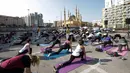 Warga Lebanon melakukan gerakan yoga selama acara "108 Sun Salutations" di ibukota Martir Beirut (22/10). (AFP Photo/Anwar Amro)