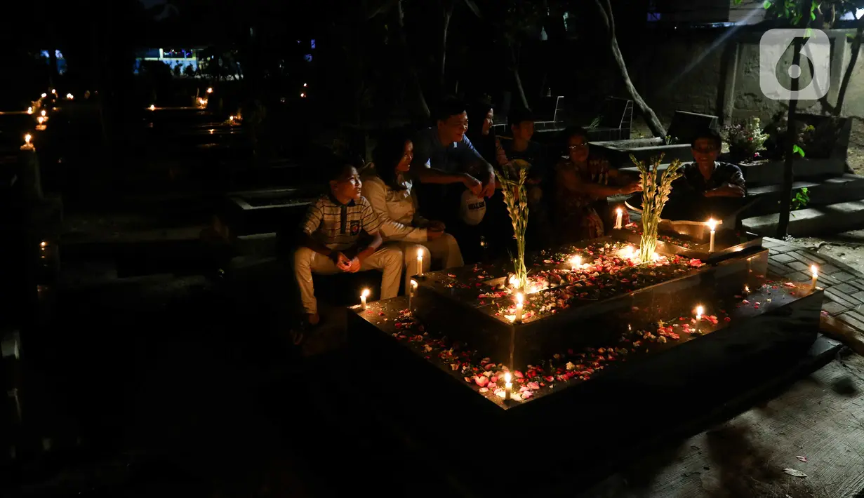 Setiap malam Natal, sejak sore hari mendekati remang-remang, mereka membawa lilin dan meletakkannya di atas makam sembari menaburkan bunga. (Liputan6.com/Herman Zakharia)