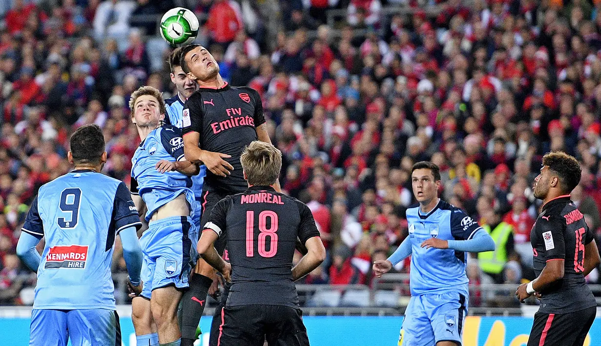 Gelandang Arsenal, Granit Xhaka, duel udara dengan bek Sydney FC, Patrick Flottmann, pada laga persahabatan di Stadion ANZ, Sydney, Kamis (13/7/2017). Arsenal menang 2-0 atas Sydney FC. (EPA/Paul Miller)