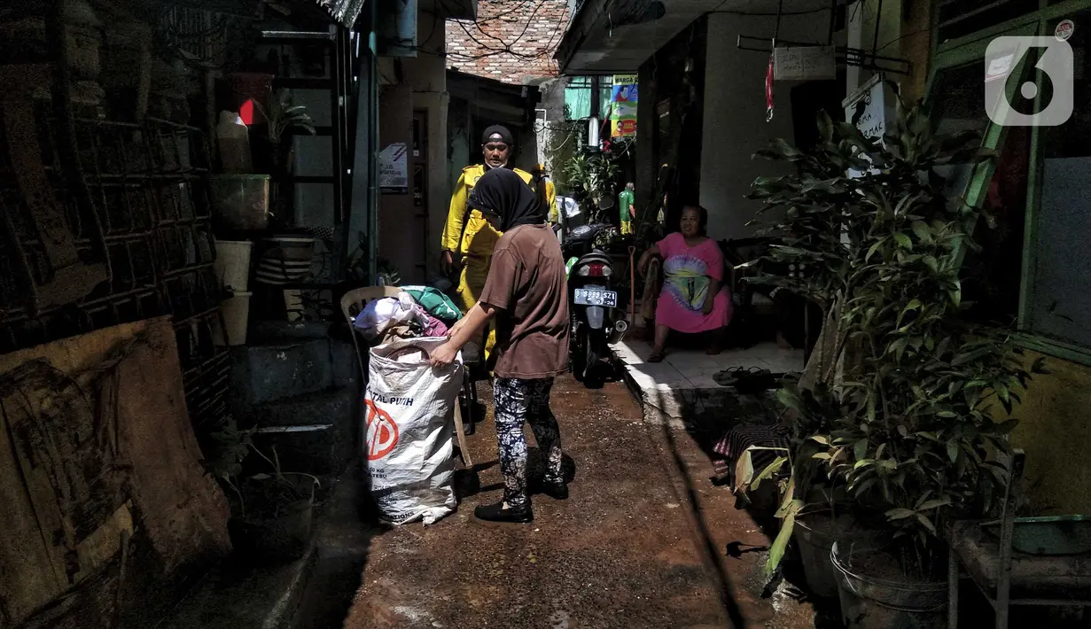 Warga membersihkan sampah sisa banjir di Kebalen, Jakarta, Minggu (21/2/2021). Banjir yang terjadi kemarin karena curah hujan yang tinggi meninggalkan sampah di rumah warga. (Liputan6.com/Johan Tallo)