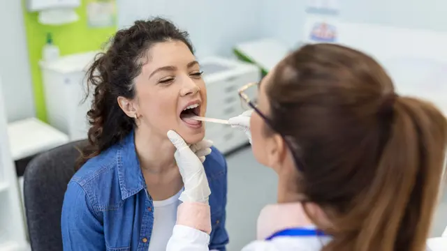 Seorang Dokter sedang Memeriksa Kondisi Lidah Pasien