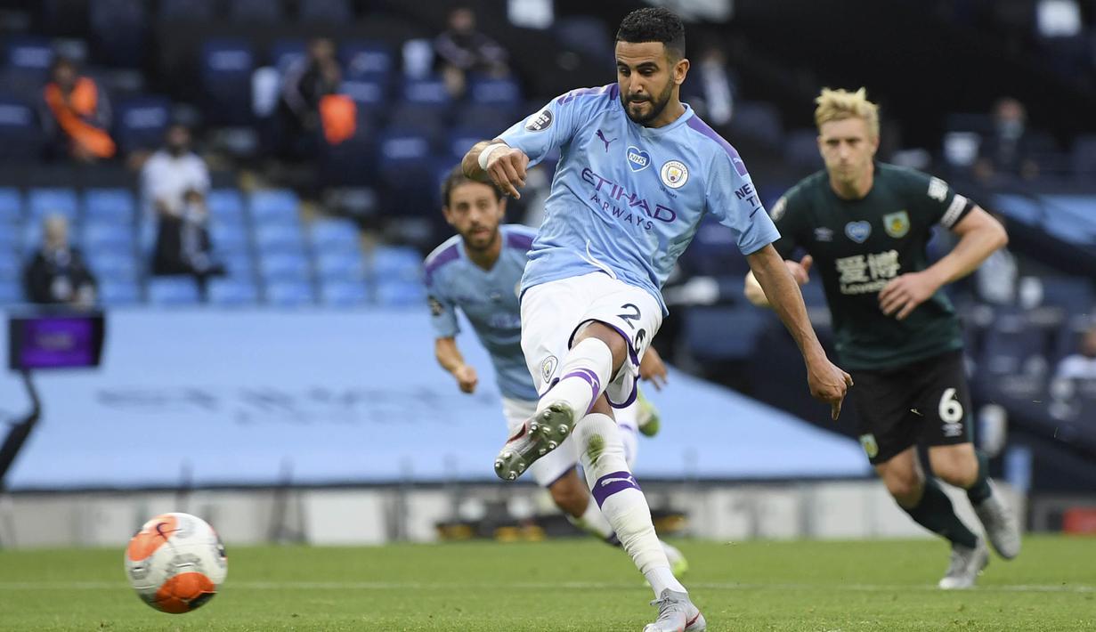 Pemain Manchester City, Riyad Mahrez, mencetak gol ke gawang Burnley pada laga Premier League di Stadion Etihad, Senin (22/6/2020). Manchester City menang 5-0 atas Burnley. (AP/Shaun Botterill)