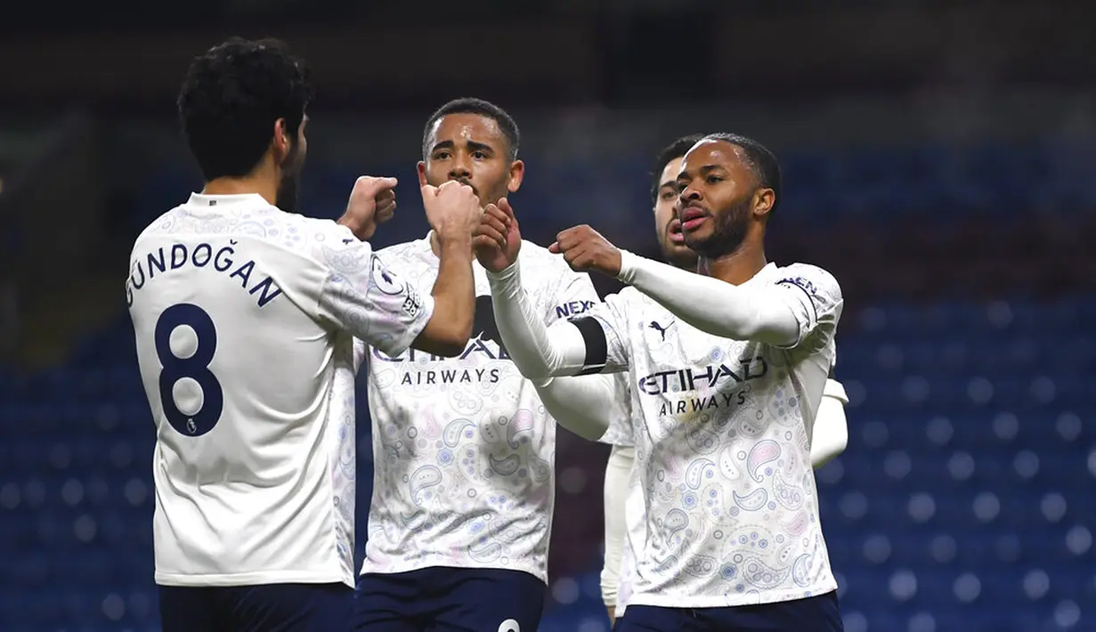Pemain Manchester City  Raheem Sterling (kanan) merayakan dengan rekan satu tim setelah mencetak gol ke gawang Burnley pada pertandingan Liga Inggris di Stadion Turf Moor, Burnley, Inggris, Rabu (3/2/2021). Manchester City menang 2-0. (Gareth Copley/Pool via AP)