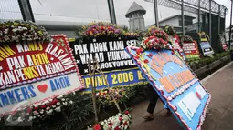 Pekerja membawa karangan bunga pesanan dari pendukung Basuki Tjahaja Purnama atau Ahok di depan Rutan Cipinang, Jakarta, Rabu (10/5). Karangan bunga terus berdatangan, meski Ahok sudah dipindahkan ke Rutan Mako Brimob, Depok. (Liputan6.com/Faizal Fanani)