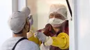Seorang petugas medis melakukan tes usap hidung saat uji virus corona COVID-19 bagi pekerja perhotelan dan pariwisata di Jalan Khao San, Bangkok, Thailand, Kamis (6/1/2022). (Jack TAYLOR/AFP)