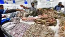 Seorang pedagang dan pembeli bertransaksi di pasar ikan yang berada di Dubai, Uni Emirat Arab, Kamis (29/3). (GIUSEPPE CACACE/AFP)