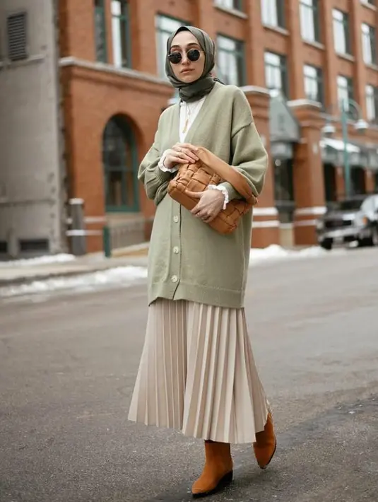 Tampil feminin dengan padu padan kardigan, rok plisket warna pastel, dan sepatu boots warna cokelat. (Instagram/elifd0gan).
