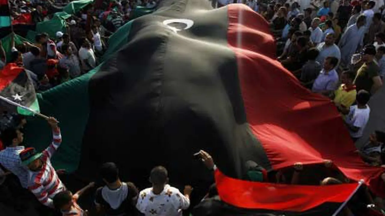 Para pengunjuk rasa membawa bendera raksasa Kerajaan Libya saat aksi menentang pemimpin Libya Muammar Gaddafi di Misrata, Rabu (6/7).(Antara)