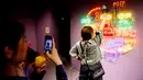 Seorang pengunjung berpose di depan tulisan toilet dalam berbagai bahasa di Museum Unko di Yokohama, Jepang pada Rabu (17/4). Untuk masuk ke dalam museum seni ini, traveler harus membayar tiket 1.600 Yen (Rp 205 ribu) untuk dewasa, dan 900 Yen (Rp 115 ribu) untuk anak-anak. (REUTERS/Kim Kyung-hoon)