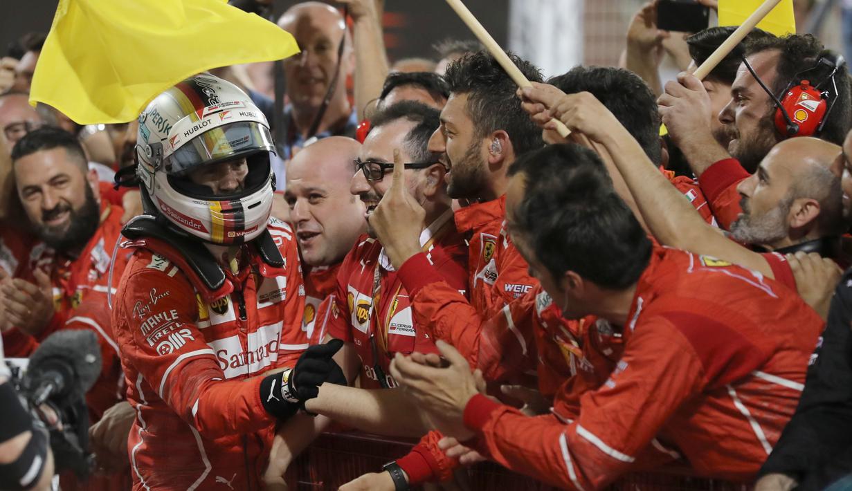 Sebastian Vettel disambut fans dan official tim usai memenangi balapan F1 GP Bahrain di Sirkuit Sakhir, Manama, Minggu (16/4/2017). (AFP/Karim Sahib)