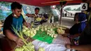 Pedagang melayani pembeli kulit ketupat di bawah kolong jembatan kawasan Pesanggrahan, Jakarta, Senin (10/5/2021). H-3 menjelang Hari Raya Idul Fitri 1442 H, penjualan kulit ketupat mulai marak yang dijual dengan harga Rp 8.000 per 10 buahnya. (Liputan6.com/Johan Tallo)
