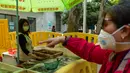 Seorang wanita membeli ikan di Wuhan, ibu kota Provinsi Hubei, China tengah, (16/4/2020). Seiring meredanya epidemi COVID-19, kehidupan berangsur kembali normal di Wuhan. (Xinhua/Shen Bohan)