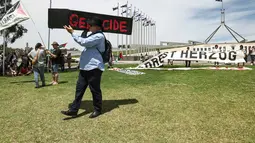 Diketahui, Isaac Herzog, berkunjung ke Australia atas undangan Perdana Menteri Anthony Albanese dan komunitas Yahudi setempat. Tampak dalam foto, seorang demonstran membawa peti mati tiruan saat para demonstran berkumpul di luar Gedung Parlemen menjelang pertemuan antara Perdana Menteri Australia Anthony Albanese dan Presiden Israel Isaac Herzog di Canberra pada Rabu 11 Februari 2026. (David GRAY/AFP)