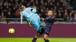 Bomber Paris Saint-Germain, Kylian Mbappe berbenturan dengan kiper Olympique Lyon, Anthony Lopes dalam lanjutan Ligue 1 di Groupama Stadium, Senin (22/1). Lopes tak sengaja menerjang Mbappe hingga terjatuh saat hendak merebut bola. (AP/Laurent Cipriani)