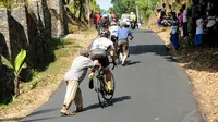 Beberapa orang mencoba membantu pebalap saat akan melintasi salah satu tanjakan yang ada di etape 3 Internasional Tour De Banyuwangi Ijen, (18/10/2014). (Liputan6.com/Helmi Fithriansyah)