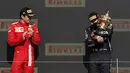 <p>Pembalap Ferrari, Charles Leclerc (kiri) melihat pembalap Mecedes, Lewis Hamilton saat memeluk pialanya di atas podium Formula 1 GP Inggris di Sirkuit Silverstone, Inggris, 18 Juli 2021. (AFP/Adrian Dennis)</p>