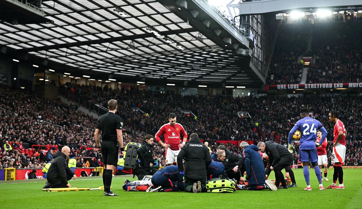 Petugas medis menangani pemain Manchester United, Lisandro Martinez yang tengah cedera dalam laga lanjutan Liga Inggris 2024/2025 melawan Crystal Palace di Old Trafford, Manchester, Inggris, Minggu (02/02/2025). (AFP/Paul Ellis)