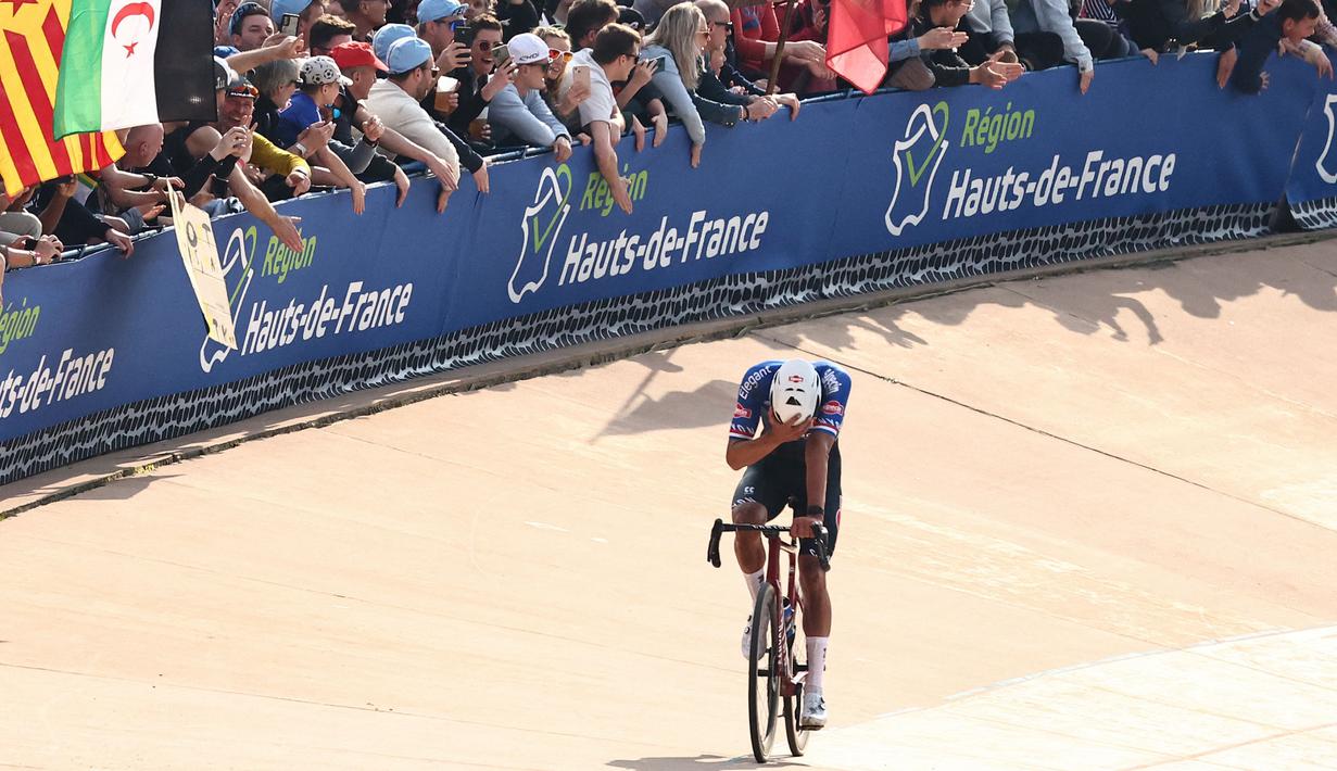Pebalap Alpecin-Deceuninck, Mathieu Van der Poel merayakan kemenangan saat ajang balap sepeda Paris Roubaix 2023 yang menempuh Compiegne hingga Roubaix, Prancis utara, 9 April 2023. (AFP/Anne-Christine Poujoulat)