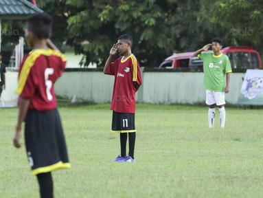 Para pemain SSB Maehanu dan SSB Persenal hormat bendera pada Liga Remaja UC News di Lapangan Masariku Yonif 733, Ambon, Selasa (28/11/2017). SSB Maehanu menang 1-1 (5-4) atas SSB Persenal. (Bola.com/Peksi Cahyo)