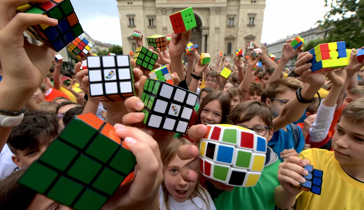 Murid-murid Hungaria berpose dengan Kubus Rubik usai melakukan flashmob di Budapest pada 12 Juni 2024. (Ferenc ISZA/AFP)
