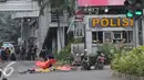 Petugas menutup mayat korban ledakan bom di pos pol sarinah, Jakarta, Kamis, (14/1/2016). Beberapa ledakan dan suara senjata api terjadi di pusat ibukota Indonesia, Polisi mencurigai seorang melakukan aksi bom bunuh diri. (Liputan6.com/Angga Yuniar)