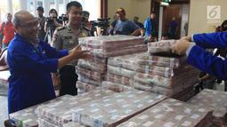 Pegawai menata uang ganti rugi korupsi BLBI dengan terpidana Samadikun Hartono di Gedung Bank Mandiri, Jakarta, Kamis (17/5). Samadikun membayar tunai sisa uang pengganti sesuai dengan vonis yang diterimanya senilai Rp 87. (Liputan6.com/Angga Yuniar)