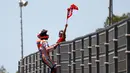 Pembalap Repsol Honda, Marc Marquez memanjat pagar lintasan setelah berhasil finis pertama pada balapan MotoGP Spanyol 2018 di Sirkuit Jerez, Minggu (6/5). Marquez mengukir waktu 41 menit 39,678 detik. (AP Photo/Miguel Morenatti)