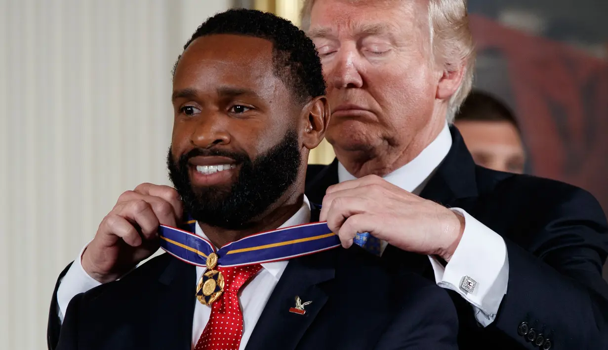 Presiden Donald Trump memberikan Medali Kehormatan kepada petugas polisi Capitol Hill, David Bailey di Gedung Putih, Washington, (27/7). Aksi penembakan dilakukan seorang pria bersenapan dan telah tewas. (AP Photo/Evan Vucci)