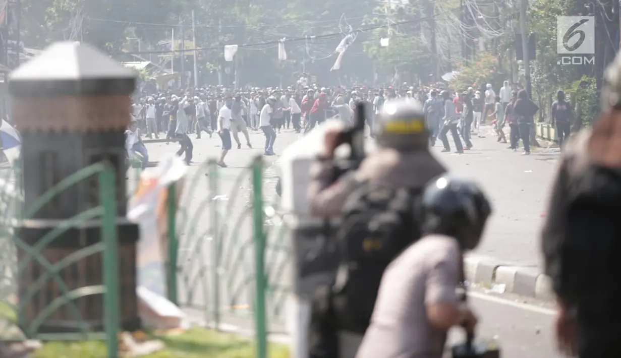 Massa aksi melemparkan batu ke arah petugas selama demo di Petamburan, Jakarta Barat, Rabu (22/5/2019). Massa aksi masih melakukan perlawanan sejak dipukul mundur oleh pihak kepolisian, dini hari tadi. (Liputan6.com/Faizal Fanani)
