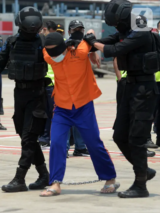Anggota Densus 88 Antiteror menggiring terduga teroris saat tiba di Bandara Soekarno-Hatta, Tangerang, Banten, Kamis (18/3/2021). Polri memindahkan 22 terduga teroris jaringan kelompok Jamaah Islamiyah (JI) dari Jawa Timur ke Jakarta. (merdeka.com/Imam Buhori)