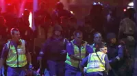 Polisi bersenjata lengkap membantu tim medis mengevakuasi para korban sandera yang terluka menjauh dari Kafe Lindt, Sydney (16/12/2014). Lebih dari 16 jam beberapa orang menjadi korban penyanderaan yang terjadi di Kafe Lindt. (REUTERS/David Gray)