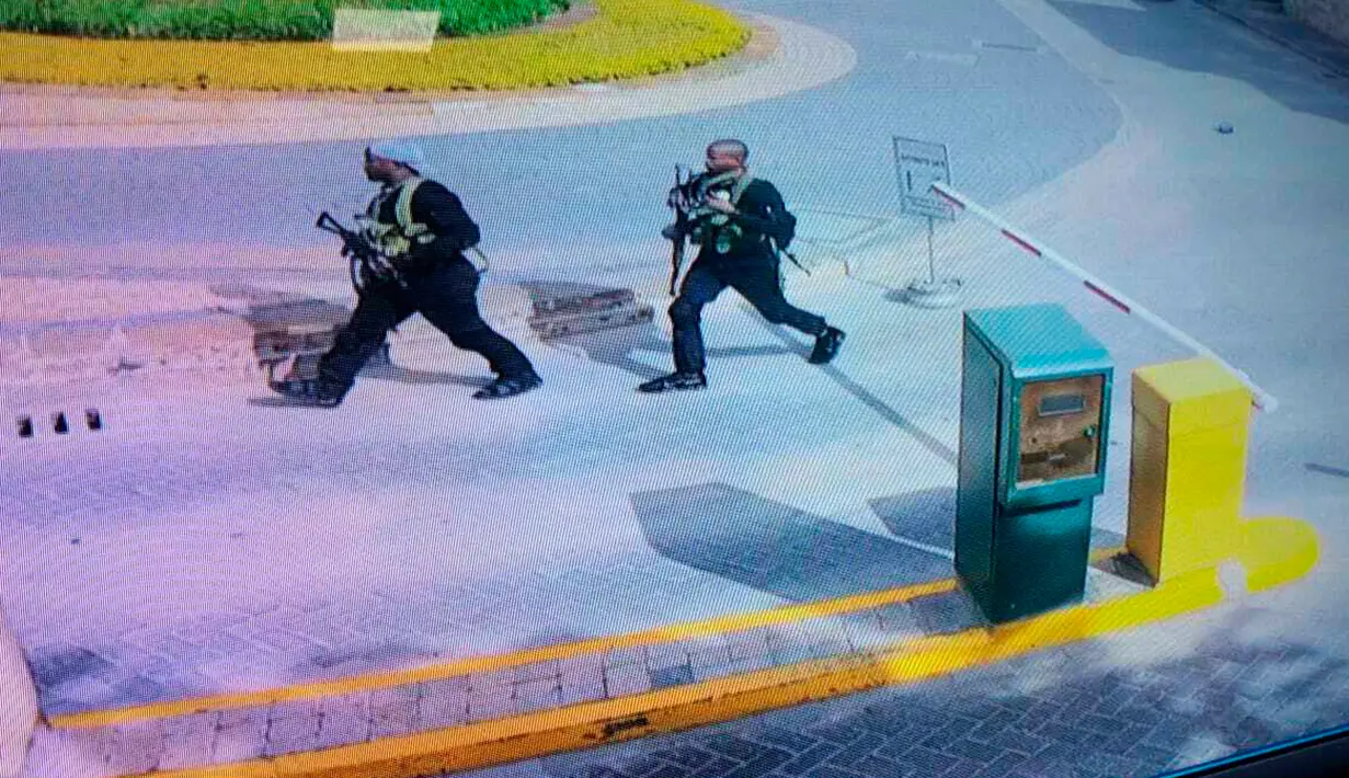 Kelompok bersenjata berjalan di sebuah kompleks hotel mewah di Nairobi, Kenya, Selasa (15/1). Serangan diawali dengan ledakan besar yang terdengar hingga jarak lima kilometer. (Security Footage Camera via AP)