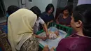 Seorang pembantu rumah tangga tampak memperaktekan cara membedong bayi. (Liputan6.com/JohanTallo)