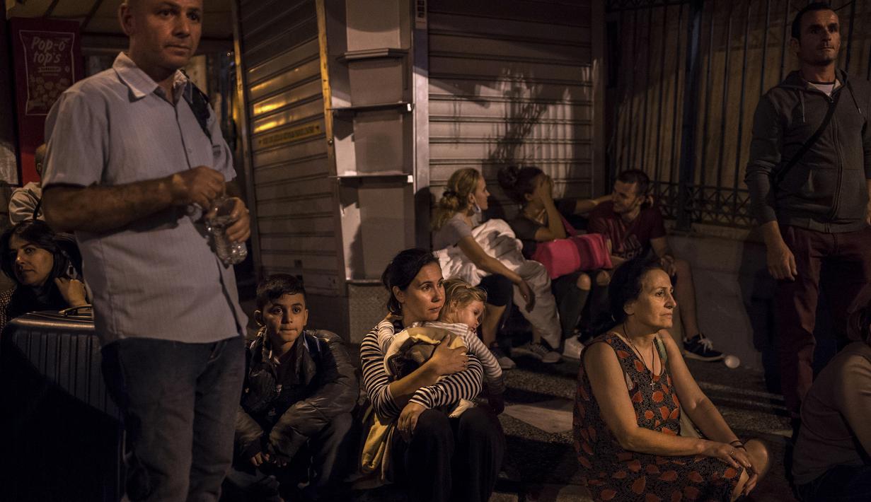 Sejumlah penumpang kapal feri Eleftherios Venizelos dievakuasi petugas saat kapal terbakar di pelabuhan Piraeus, dekat Athena, (29/8). Kapal feri tersebut mengangkut 875 penumpang dan 141 awak. (AFP Photo/Angelos Tzortzinis)