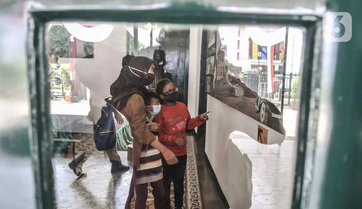 Orang tua membimbing anaknya melihat salah satu koleksi sejarah di Museum Sumpah Pemuda, Jakarta, Rabu (28/10/2020). Libur cuti bersama dimanfaatkan untuk mengajak anak-anak mengenal sejarah lahirnya Sumpah Pemuda agar memahami jejak perjuangan pahlawan sejak dini. (merdeka.com/Iqbal Nugroho)