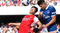 Bek Everton, James Tarkowski (kanan), berebut bola dengan pemain Arsenal, Takehiro Tomiyasu, dalam laga terakhir Premier League 2023/2024 di Emirates Stadium, London, Minggu (19/5/2024. (Adrian DENNIS / AFP)