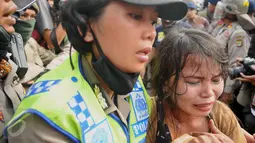 Seorang ibu menangis ketika diamankan petugas polwan dalam penggusuran di kawasan Pasar Ikan, Penjaringan, Jakarta, Senin (11/4). Warga yang didominasi perempuan itu ikut menolak penggusuran kawasan tersebut. (Liputan6.com/Gempur M Surya)