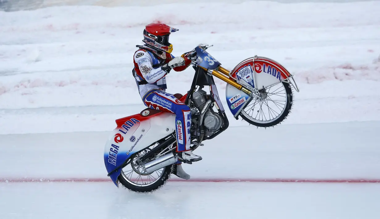 Daniil Ivanov dari Rusia beratraksi mengangkat ban depan usai melewati garis finis di FIM Ice Speedway Gladiator di Arena Medeo, Almaty, Kazakhstan (21/2). Sirkuit yang diselimuti es membuat kejuaraan ini menjadi unik. (REUTERS/Shamil Zhumatov)